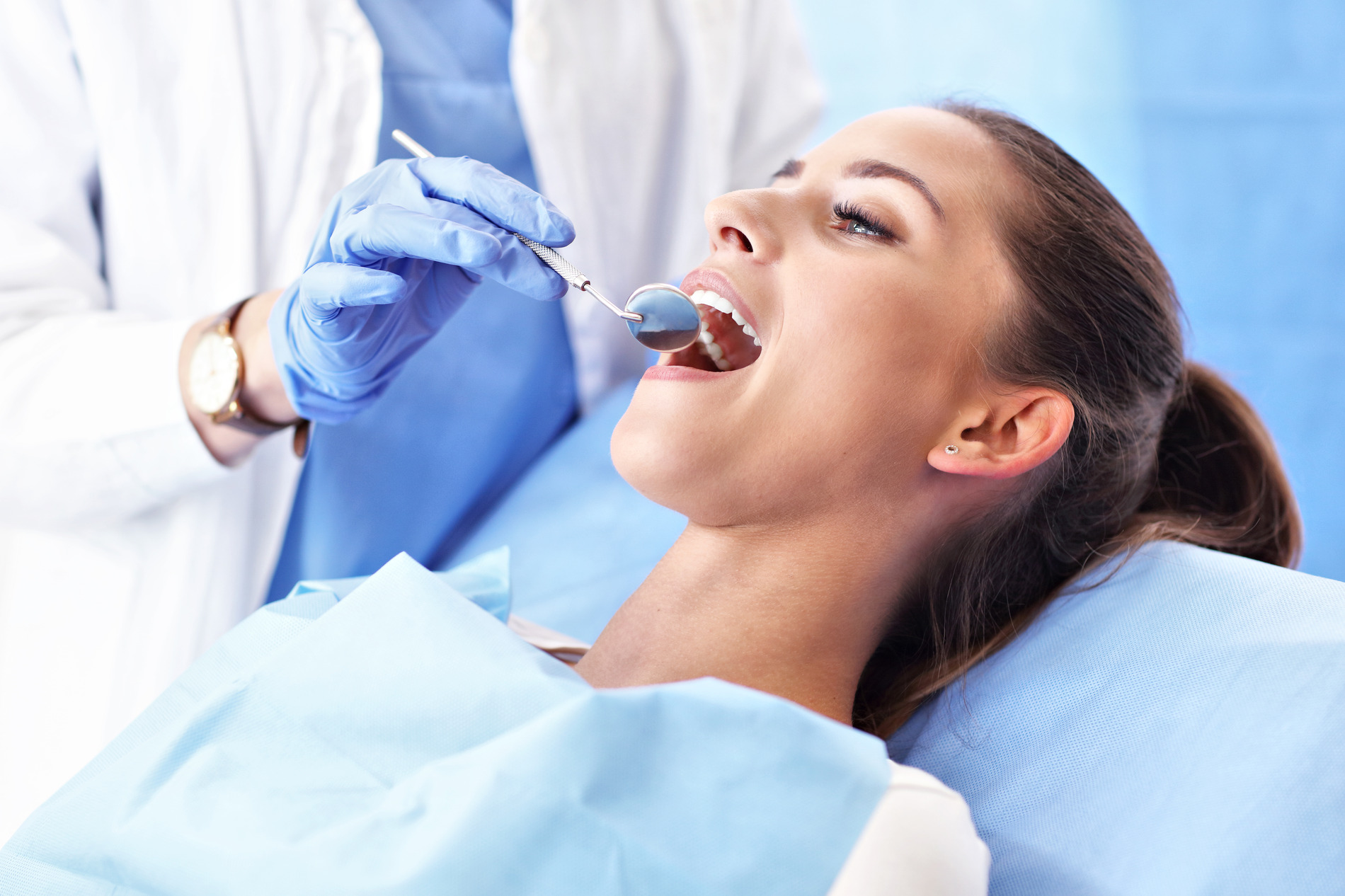 Woman at dentist recieving ceramic crowns and bridges in Golden CO