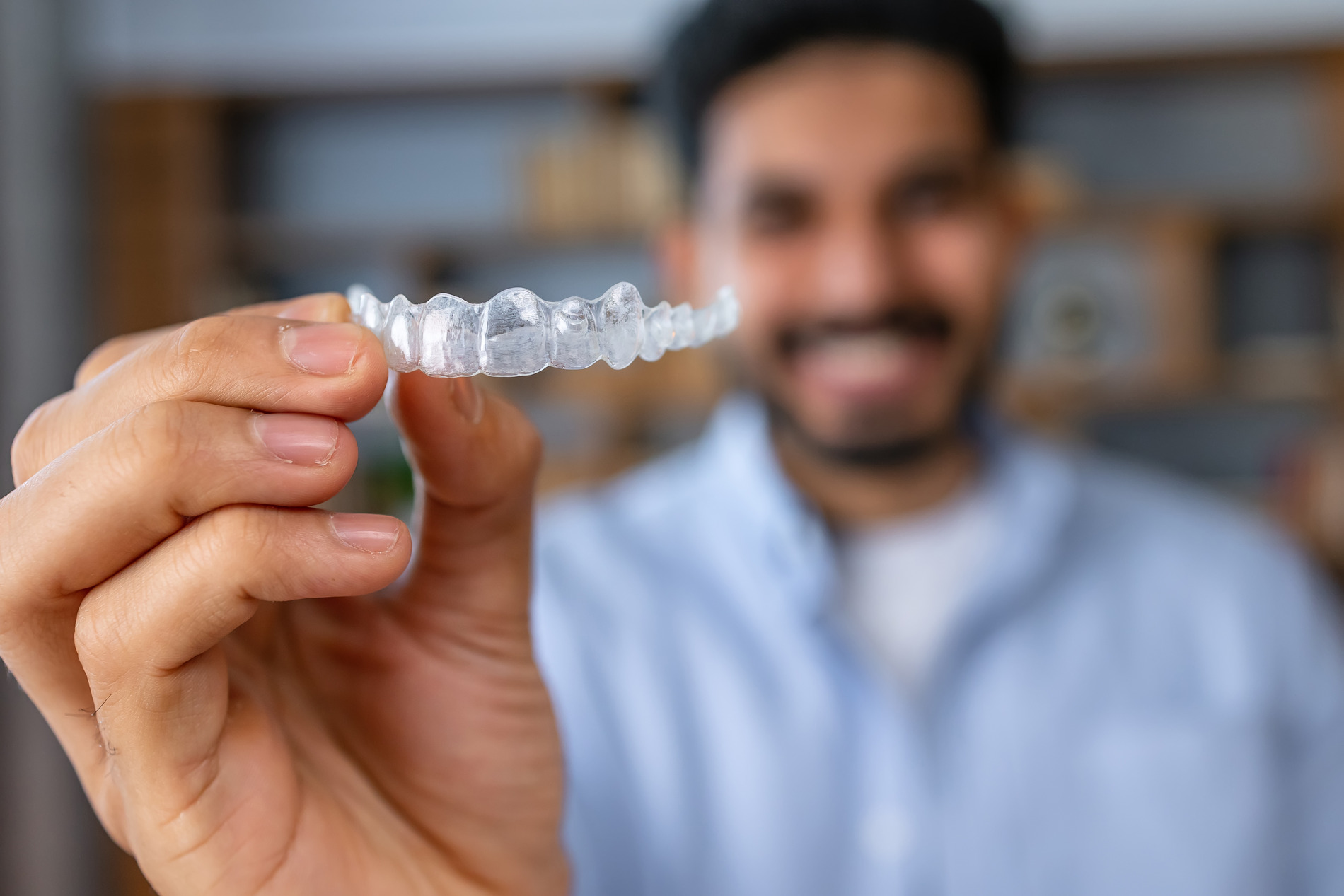 Man shows his invisalign clear aligners in Golden CO